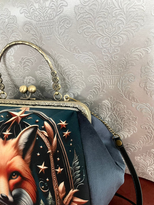 Gros plan sur le profil du sac rétro en velours bleu gris avec attaches bandoulière et poignée