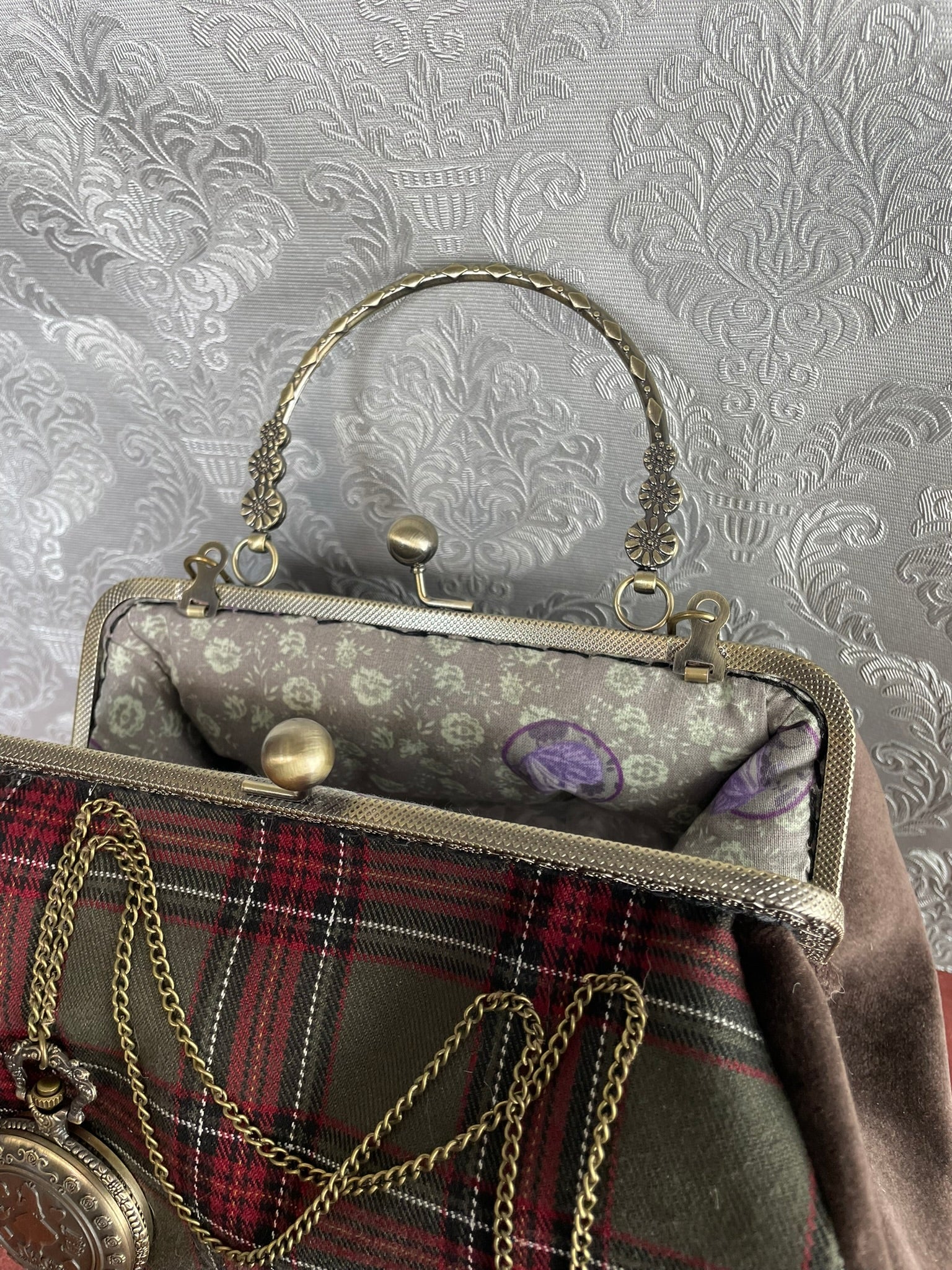 Fermoir métallique vintage avec perles et intérieur spacieux pour sac de créateur.