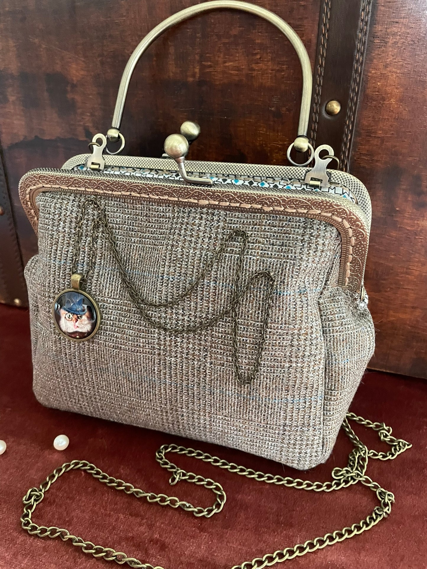 Zoom sur le médaillon bronze représentant un chat avec chapeau haut-de-forme et monocle.