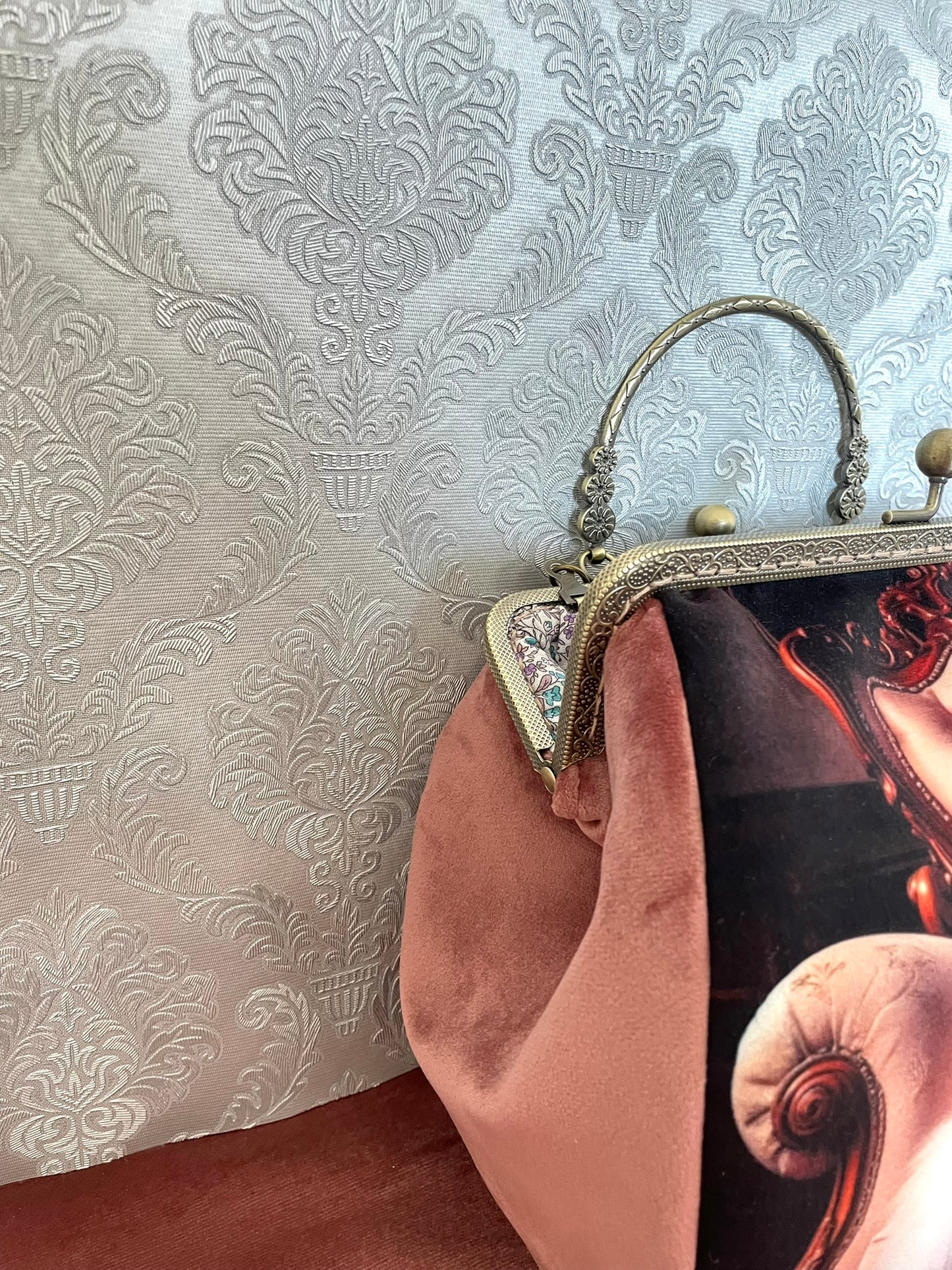 Détail du côté en velours doux couleur vieux rose saumoné d'un sac à main style vintage et rétro chic.