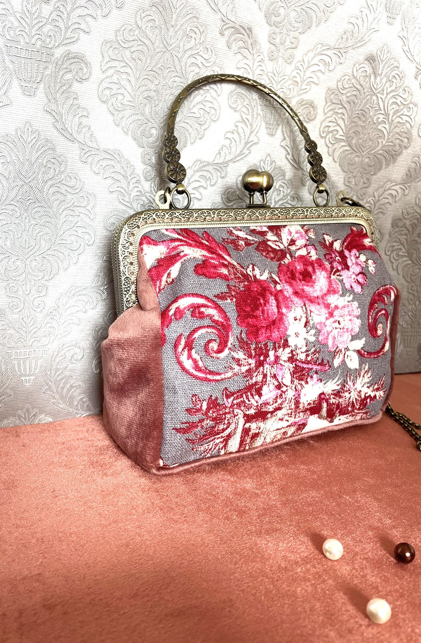 Vue de face du sac vintage Toile de Jouy avec sa poignée rigide en bronze sculpté de motifs floraux.