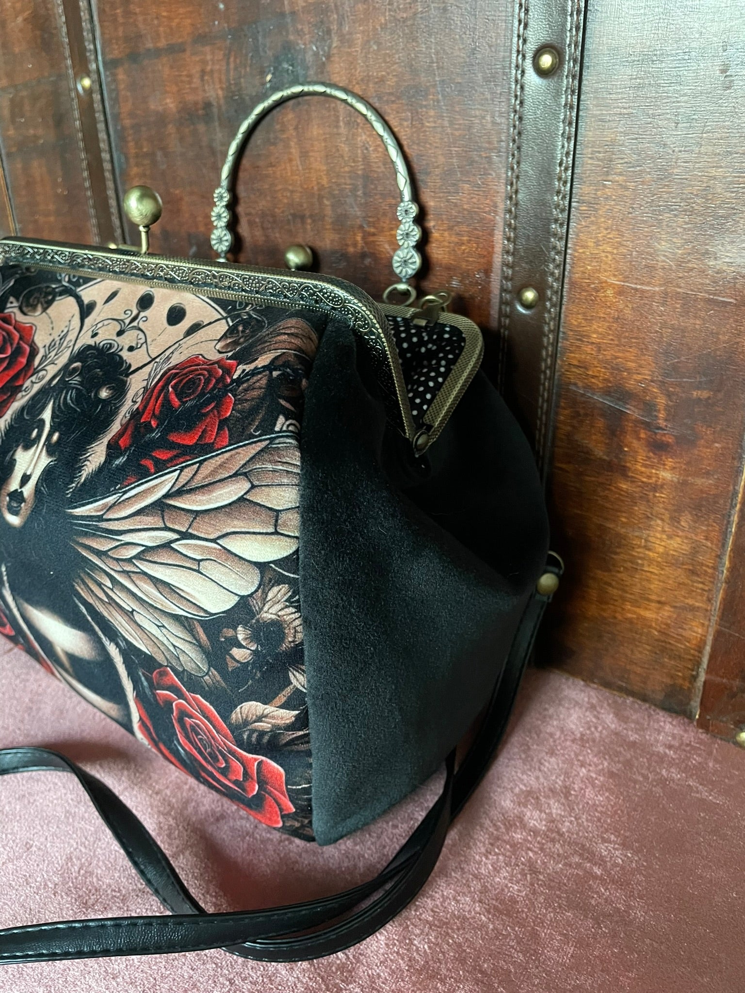 Vue de profil du sac en velours noir montrant le volume et la finition artisanale.